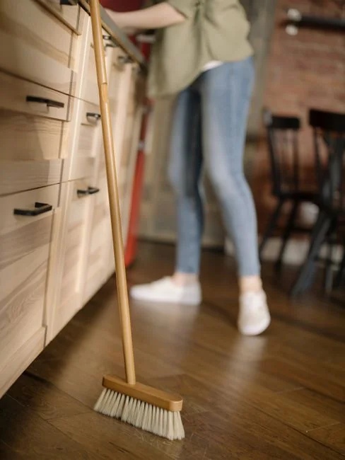 A hotel housekeeper neatly stacks fresh towels in a luxurious room setting.